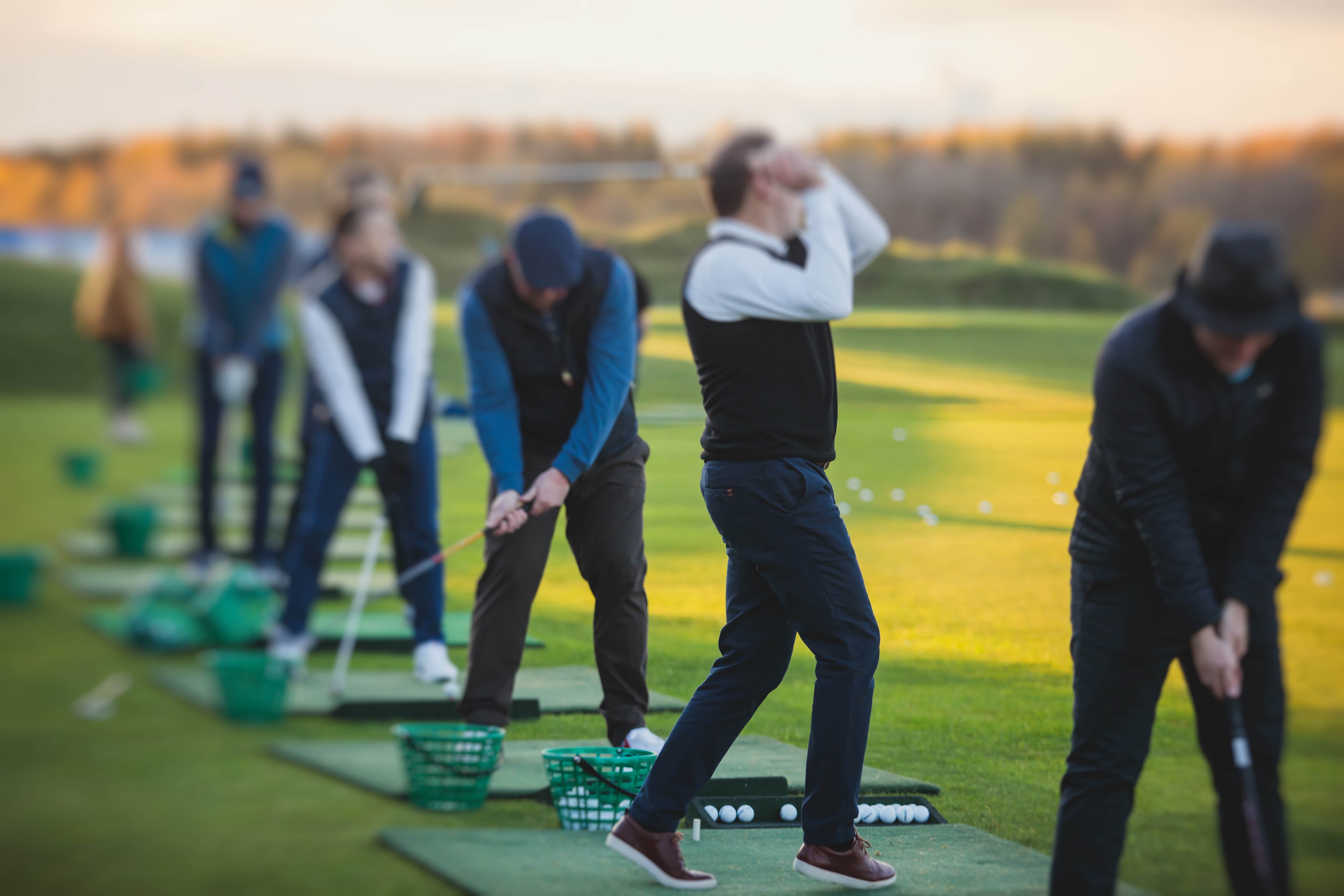 Group at the driving range on the golf course Group at the driving range on the golf course